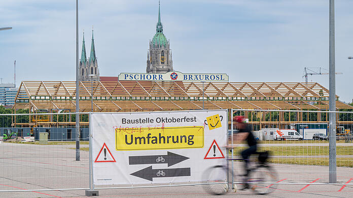 Ein Plakat mit der Aufschrift "Umfahrung" hängt zu Beginn des offiziellen Start zum Oktoberfest-Aufbau an einem Tor des ansonsten eingezäunten Wiesn-Gelände.