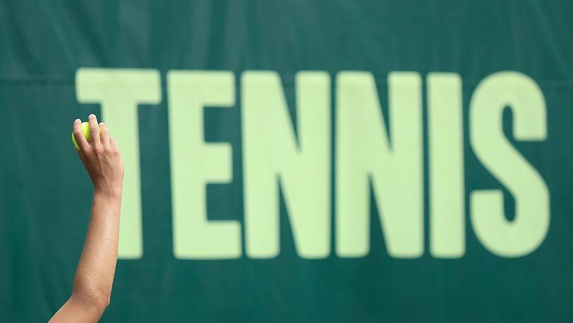 "Tennis" steht bei einem Turnier auf einer Plane. "Tennis" steht bei einem Turnier auf einer Plane.