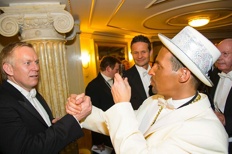 Ein als Kanye West verkleideter Ballgast möchte ein Foto mit dem Moderator.