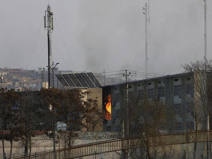 Aus einem Regierungsgebäude steigen nach einer Explosion Flammen auf.