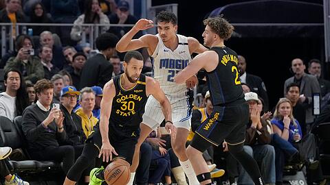 Orlandos Tristan da Silva (Mitte) sammelte gegen All-Star Stephen Curry (l.) zwei Pünktchen.