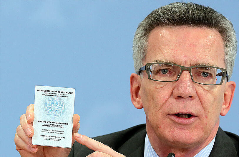 Bundesinnenminister de Maiziere zeigt einen sogenannten Ersatzpersonalausweis, der nach Entzug des normalen Ausweises ausgestellt wird.