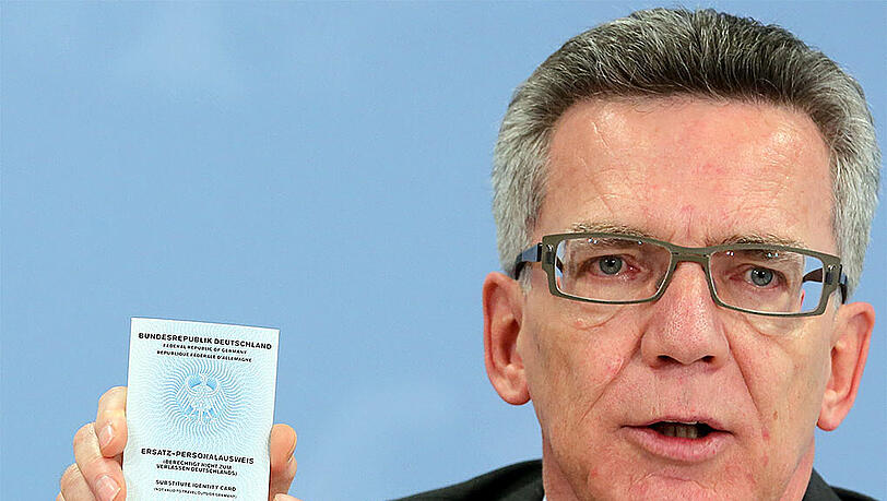 Bundesinnenminister de Maiziere zeigt einen sogenannten Ersatzpersonalausweis, der nach Entzug des normalen Ausweises ausgestellt wird. Bundesinnenminister de Maiziere zeigt einen sogenannten Ersatzpersonalausweis, der nach Entzug des normalen Ausweises ausgestellt wird.