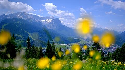 Sommer in den Bergen: Der Wank in Bayern ist ein beliebtes Reiseziel, auch für die Bürger im Freistaat selbst. Im Hintergrund sind die Gipfel des Wettersteins mit der Zugspitze zu sehen. Aber: der Urlaub in Bayern wird immer teurer.
