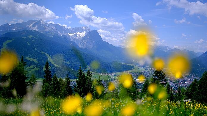 Sommer in den Bergen: Der Wank in Bayern ist ein beliebtes Reiseziel, auch für die Bürger im Freistaat selbst. Im Hintergrund sind die Gipfel des Wettersteins mit der Zugspitze zu sehen. Aber: der Urlaub in Bayern wird immer teurer.