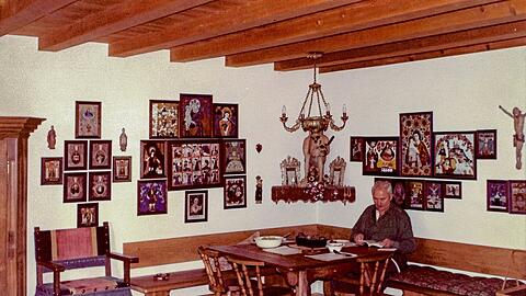 Der Roider Jackl, umgeben von Hinterglasbildern und religi&ouml;ser Volkskunst, in seinem Freisinger Wohnzimmer.