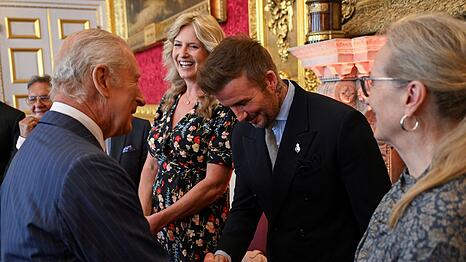 Der britische König Charles III (l) und David Beckham kennen sich seit Jahren persönlich.