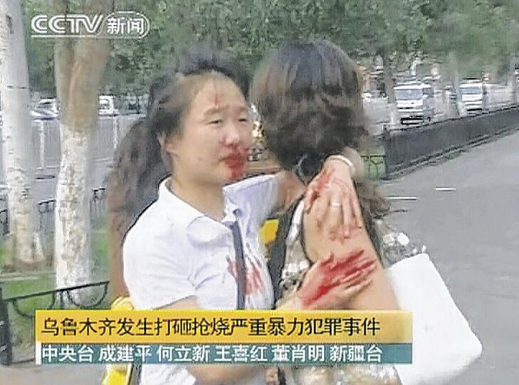 Blutend und weinend halten sie sich in den Armen: Zwei Frauen während der Ausschreitungen in der Uiguren-Hauptstadt Urumqi. Foto: Reuters