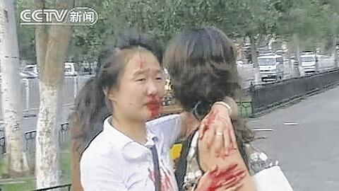 Blutend und weinend halten sie sich in den Armen: Zwei Frauen während der Ausschreitungen in der Uiguren-Hauptstadt Urumqi. Foto: Reuters