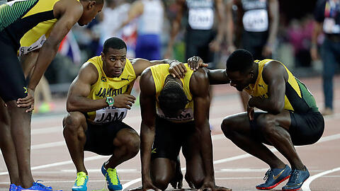 Nach dem Staffelfinale muss der "gefallene Held" Usain Bolt von seinen jamaikanischen Mannschaftskollegen getröstet werden.