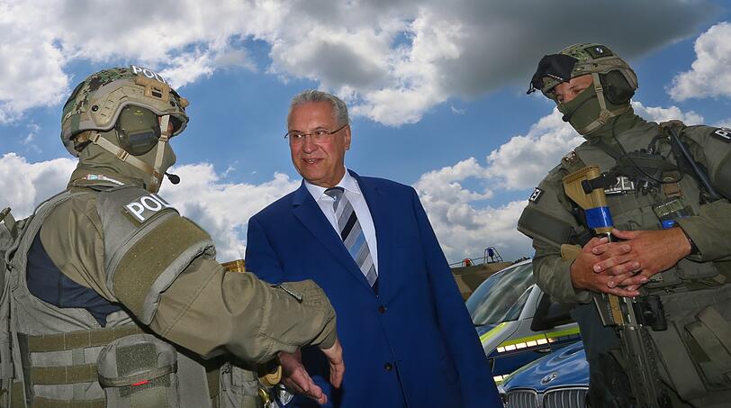 Innenminister Joachim Herrmann (CSU) spricht bei einer Übung auf dem Fliegerhorst Penzing mit zwei Polizisten des SEK.