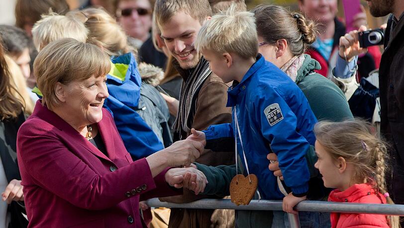 Auf Augenhöhe mit den Kleinsten: Kanzlerin Angela Merkel schüttelt bei ihrer Ankunft in Nürnberg einem Bub die Hand. Auf Augenhöhe mit den Kleinsten: Kanzlerin Angela Merkel schüttelt bei ihrer Ankunft in Nürnberg einem Bub die Hand.