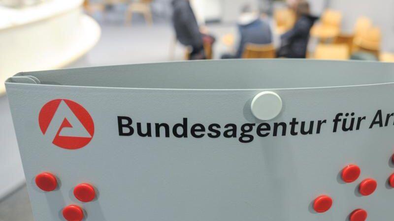 Blick in den Wartebereich der Bundesagentur für Arbeit hinter einem Aufsteller mit dem Logo der Agentur. Foto: Larissa Schwedes/Archivbild
