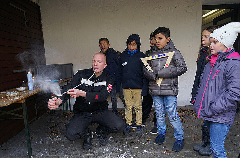 Mit Mehl zeigt ein Feuerwehrmann, wie auch ungewöhnliche Materialien in Brand geraten können.