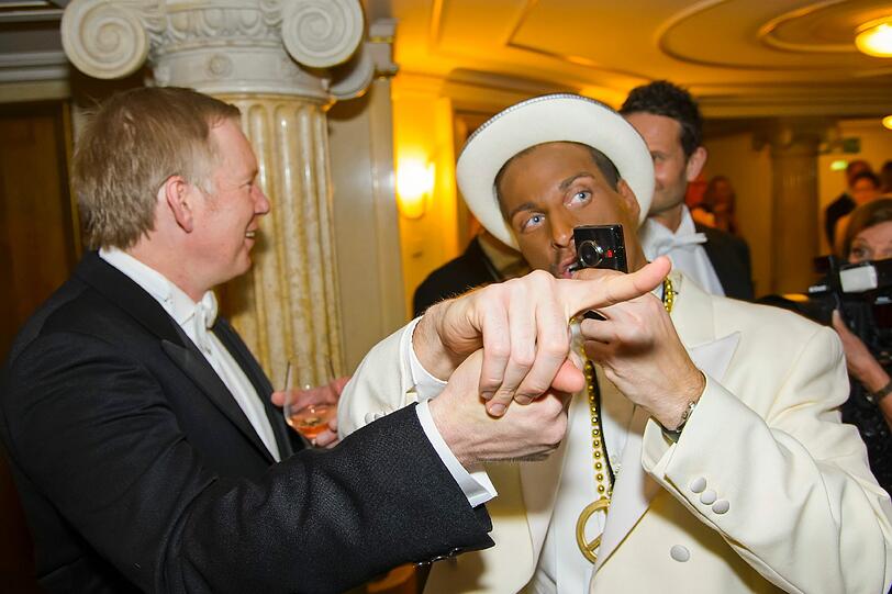 Ein als Kanye West verkleideter Ballgast möchte ein Foto mit dem Moderator.