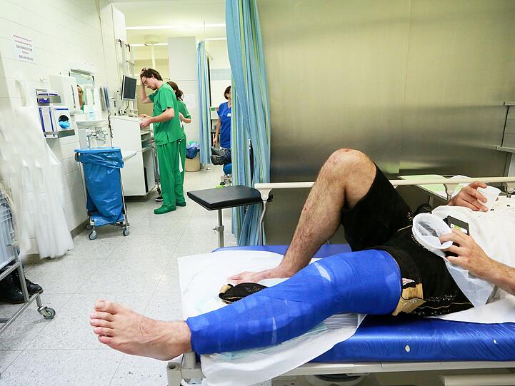 Das ganz normale Wiesn-Gschäft: ein Patient mit soeben vernähten Schnittverletzungen. In der Hand hält er Spucktüte und Wasserbecher.