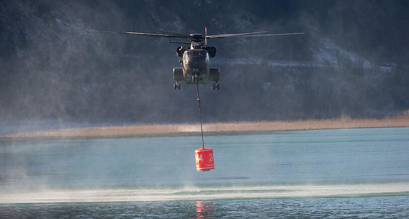 Die vier eingesetzen Hubschrauber füllen ihre Wassertanks aus dem Sylvenstein-Stausee