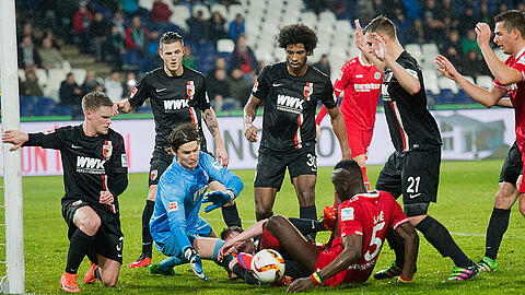 Wildes Getümmel im Augsburger Strafraum: Torwart Marwin Hitz, Augsburgs Paul Verhaegh und Hannovers Salif Sane kämpfen um den Ball, die Augsburger Philipp Max (von links nach rechts), Jeffrey Gouweleeuw, Caiuby und Dominik Kohr schauen zu.