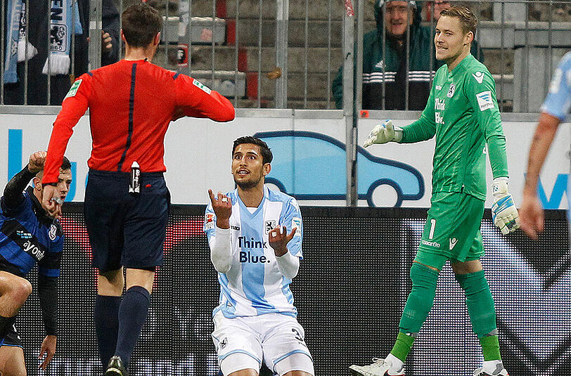 Sertan Yegenoglu (links) protestiert nach seinem Foul, das zum Elfmeter gegen die Löwen und zum entscheidenden Gegentreffer führte. Rechts 1860-Keeper Vitus Eicher.