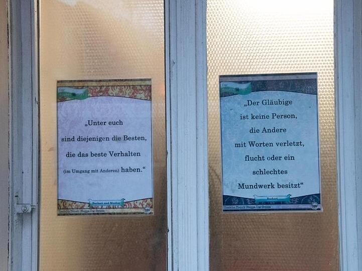 An der Fensterscheibe der Moschee sind Zettel mit religiösen Botschaften angebracht.