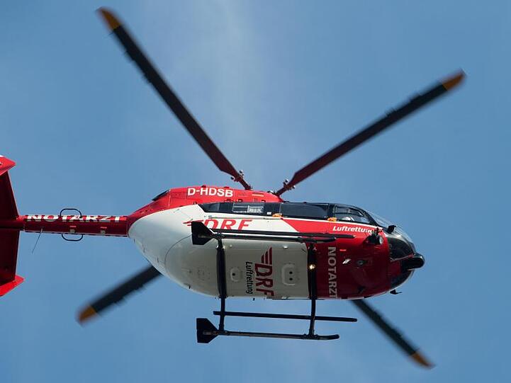 Ein Rettungshubschrauber fliegt über einen Flugplatz. Foto: Stefan Sauer/zb/dpa/Symbolbild