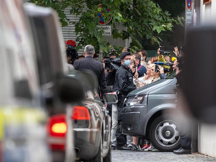 Zahlreiche Schaulustige beobachten die Autokolonne mit dem emeritierten Papst Benedikt XVI. Foto: Armin Weigel/dpa