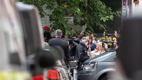 Zahlreiche Schaulustige beobachten die Autokolonne mit dem emeritierten Papst Benedikt XVI. Foto: Armin Weigel/dpa