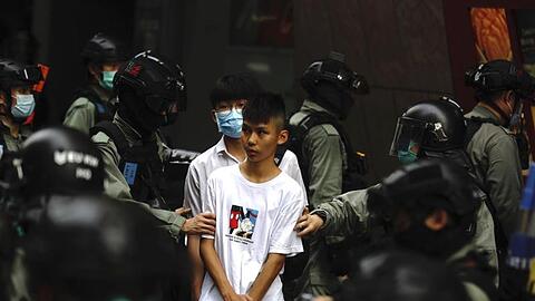 Bereitschaftspolizisten halten im Zentrum von Hongkong zwei junge Demonstranten fest.