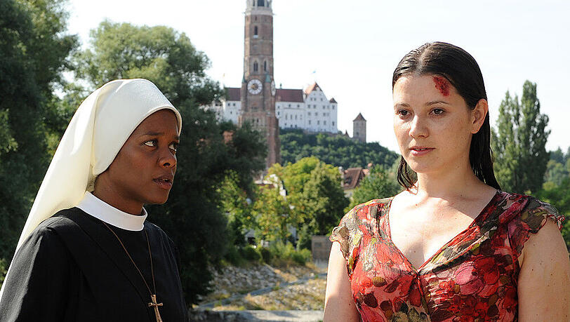 Schwester Lela (Denise M'Baye, l.) findet Claudia (Mareike Lindenmeyer, r.), die tropfnass und blutend auf einer Brücke steht