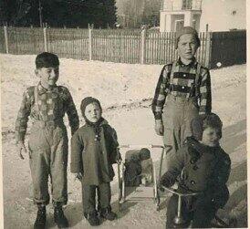 1957: Spielen im Schnee. Puppenwagen und Dreiradl sind der ganze Stolz der Kinder.