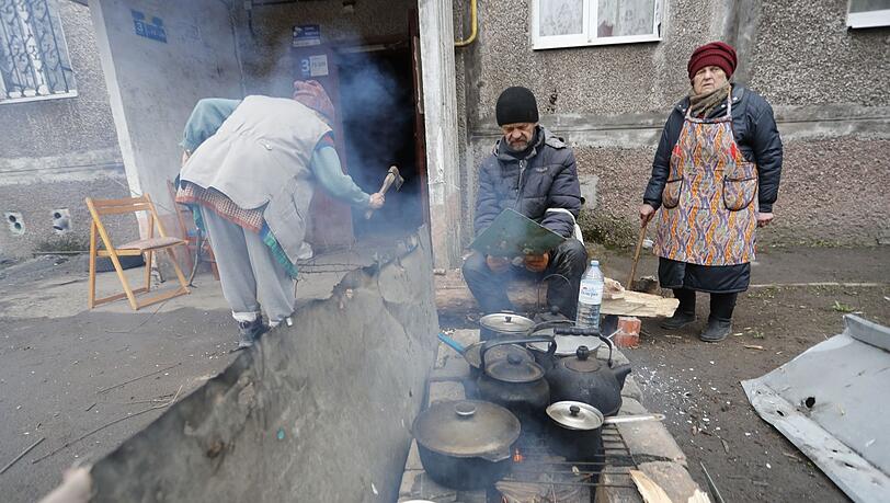 Einwohner kochen in Mariupol im Freien.