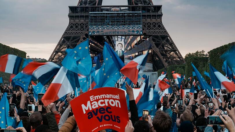 Anhänger des französischen Präsidenten Macron reagieren am Eiffelturm auf die Bekanntgabe der Wahlprognosen. Anhänger des französischen Präsidenten Macron reagieren am Eiffelturm auf die Bekanntgabe der Wahlprognosen.