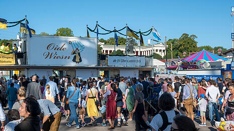 Besucher stehen am Eingang zur Oiden Wiesn Schlange. Ein neues Einlass-System soll da Abhilfe schaffen.  (Archivbild)