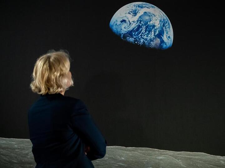 Eine Frau betrachet das Bild "Earthrise". Foto: Daniel Karmann