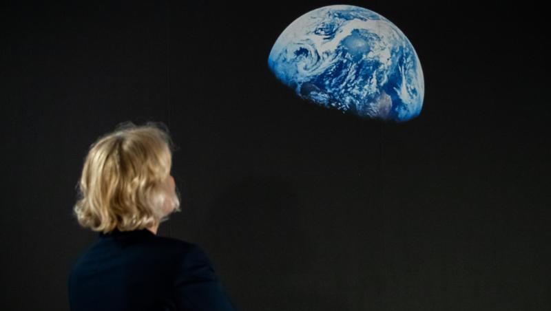 Eine Frau betrachet das Bild "Earthrise". Foto: Daniel Karmann Eine Frau betrachet das Bild "Earthrise". Foto: Daniel Karmann