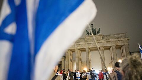 Menschen erinnern am Brandenburger Tor an die Opfer des 7. Oktober.