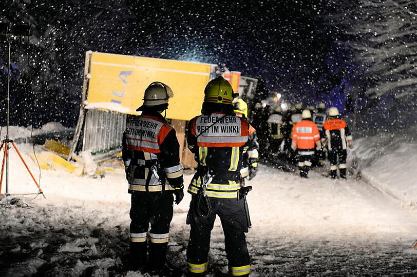 Ein LKW kommt auf schneeglatter Fahrbahn ins Rutschen und kippt um