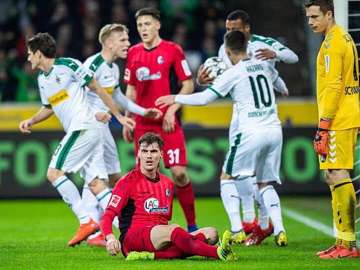 Die Gladbacher Spieler freuen sich im Hintergrund über den Treffer zum 1:1-Ausgleich gegen Freiburg.