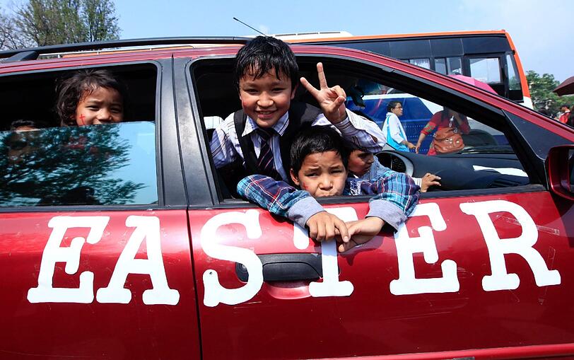 Nepalesischer Kinder kommen in einem dekorierten Auto in Kathmandu, Nepal, an um am Massengebet am Ostersonntag teilzunehmen.