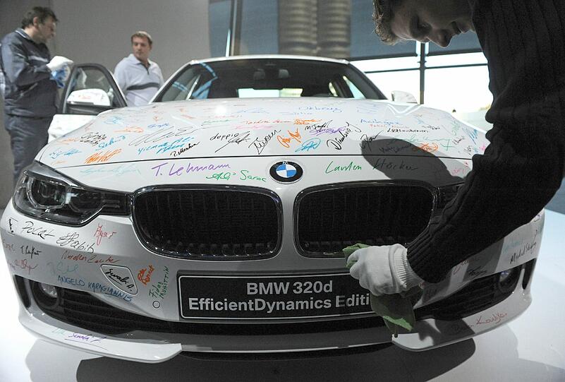 Polieren für die Weltpremiere. BMW-Mitarbeiter vor dem neuen 3er.