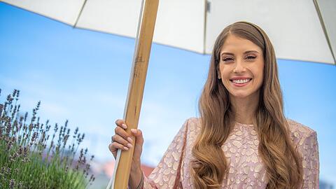 Cathy Hummels, Influencerin und Moderatorin, steht unter einem Sonnenschirm.