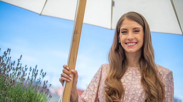 Cathy Hummels, Influencerin und Moderatorin, steht unter einem Sonnenschirm.