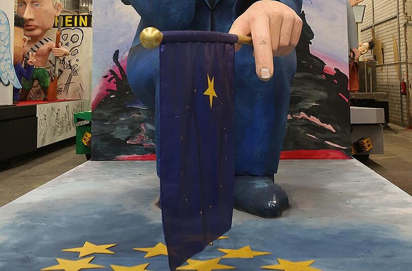 Sie hält eine Europafahne in der Hand, auf der nur noch ein Stern zu sehen ist.