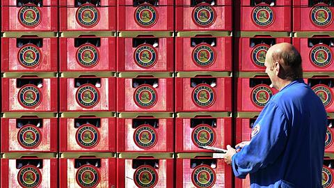 Rot und mit Logo: Ein Mitarbeiter von Paulaner kontrolliert eine Lieferung Biertragl.