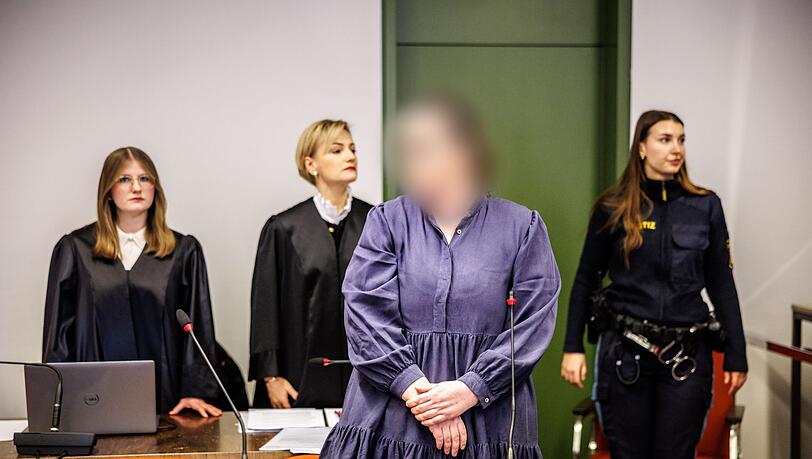 Die Angeklagte Andrea Tandler (2.v.r) steht zu Prozessbeginn an ihrem Platz im Gerichtssaal.