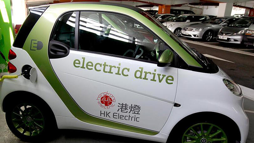 Ein Mercedes-Benz Smart Fortwo Elektroauto tankt an einer öffentlichen Ladestation in Hongkong auf.