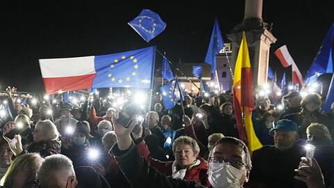 Menschen halten während einer Demonstration in Warschau die Taschenlampen ihrer Mobiltelefone hoch.