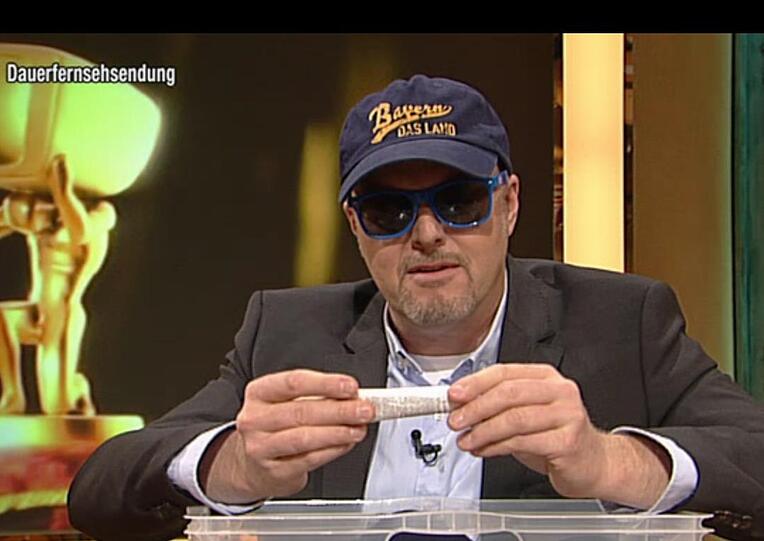 Stefan Raab mit "Bayern - Das Land"-Mütze und CSU-Sonnencreme.