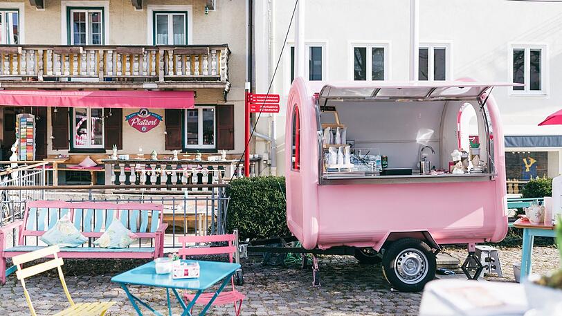 "Bevor Elisabeth Schwojer morgens die Türen zu ihrem Café öffnet, findet man sie häufig auf den umliegenden Bergen. Die Frische, die sie dort einfängt, bringt sie mit in ihr Elisabeths Platzerl. Dort backt, bastelt und wirbelt sie durch ihre rosa Welt. Ihr mobiles Café-Wagerl vor dem Haus ist unverkennbar und weithin sichtbar."