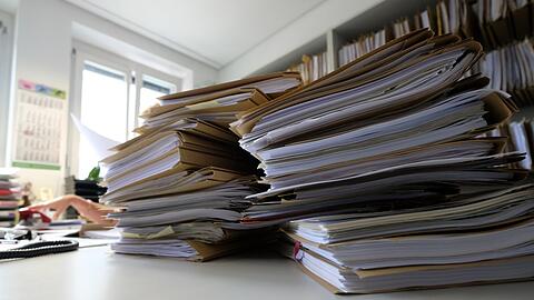 Akten liegen auf einem Tisch. Die Bürokratiebelastung in Deutschland hat in der Vergangenheit stetig zugenommen.